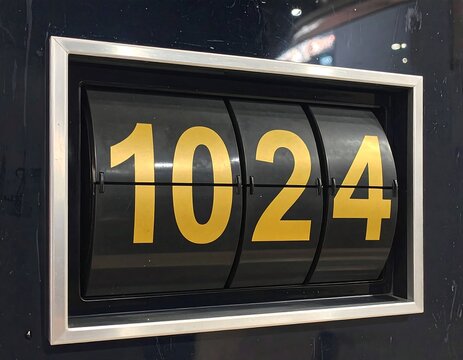 A close-up of a black sign with a silver frame displaying the number 1024
