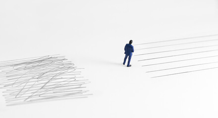 Conceptual image showing contrast between chaos and order with a miniature businessman standing...