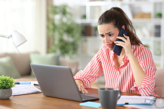 Disgusted self employed checking laptop talking on phone