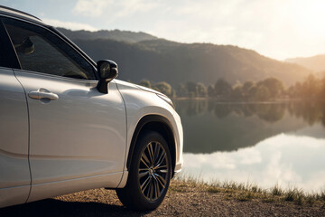 Fototapeta premium SUV blanc gare prÃ¨s dâ€™un lac calme, vue de profil lateral, no people, lumiÃ¨re matinale douce, reflets realistes sur la carrosserie, esthetique publicitaire propre et moderne