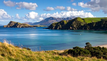 Fototapeta premium A serene coastal landscape with rolling hills, blue waters, and a distant mountain