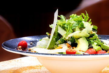Fresh healthy salad with green lettuce cherry tomatoes and sliced avocado close-up