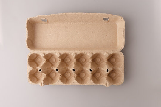 Empty cardboard egg carton open top view on grey background. Eco friendly recycled paper packaging for grocery store poultry product organic farming delivery sustainability zero waste concept