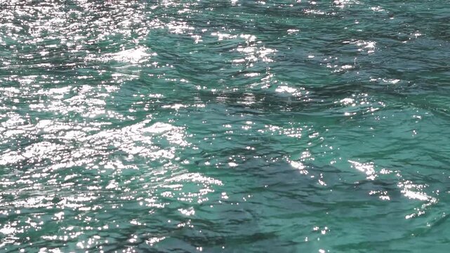 Close Up of Shimmering Turquoise Sea Water with Sunlight Sparkling on the Rippling Waves