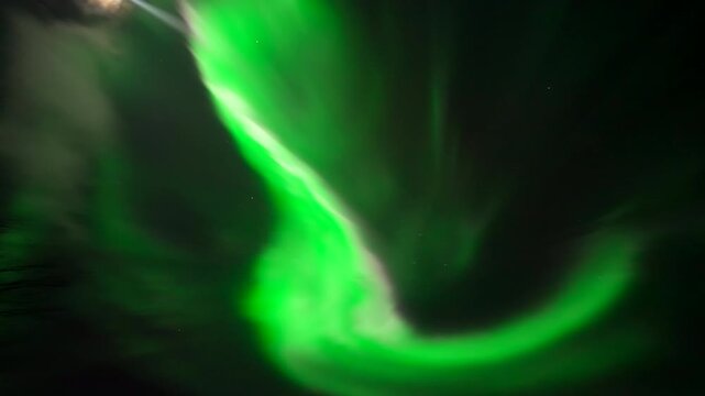 Close telephoto backdrop of bright green aurora borealis swirling in Tromso Norway night sky, eruption shimmering surreal pires