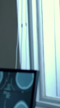 Vertical video: Pointing tech sleeved hand entering, tapping monitor at clinic reading brain scans