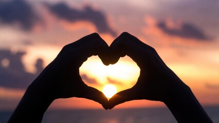 Hands forming heart shape around sun over calm sea at dusk