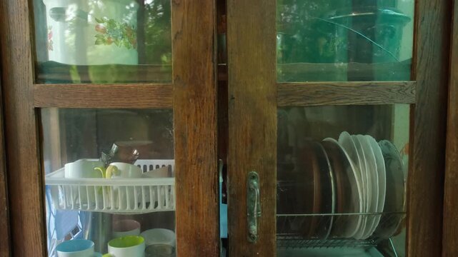Vintage wooden kitchen sideboard with glass doors and ceramic plates