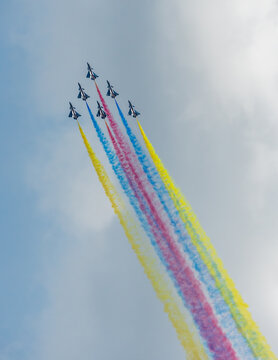 Aerial view of fighter jets soaring, painting the sky with vibrant trails of red, yellow, and blue, Changi Exhibition Centre, Singapore Air Show 2026, Singapore.