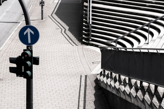 Mobility themed urban street scene with traffic signal arrow sign and graphic shadow by architecture in Hamburg Germany showing direction and form