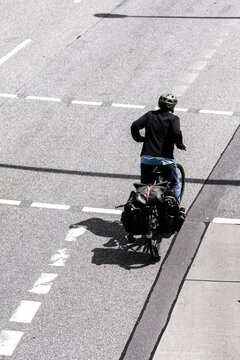 Urban mobility overhead view of a cyclist on bicycle crossing an intersection in Hamburg Germany showing commute flow street markings and crossing