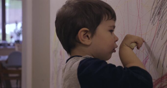Petit gar&ccedil;on dessinant sur mur du couloir