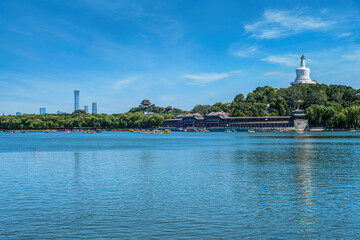 Obraz premium Scenic view of Beihai Park, Beijing, with the iconic White Pagoda, China Zun skyscraper, and the Wanchun Pavilion. This picturesque landscape blends ancient architecture with modern urban skyline.