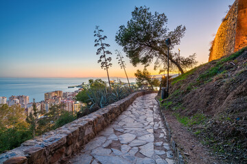 Fototapeta premium Gibralfaro hill overlooking La Malagueta district of Malaga at sunset