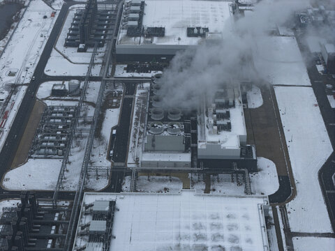 Aerial view of a large ai data center facility operating in winter conditions with steam emitting from cooling towers, Eemshaven, Netherlands.