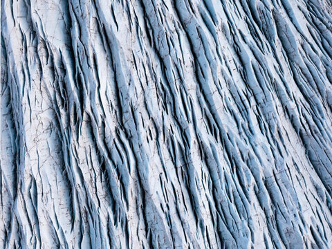 Aerial view of the stark, crevasse-riddled expanse of Svinafellsjokull glacier, a frozen river of blue and white ice sculpted by time and weather, Svinafell, Sveitarfelagid Hornafjordur, Iceland.