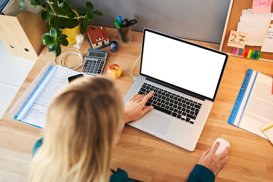 Woman typing on laptop with blank screen at home office desk