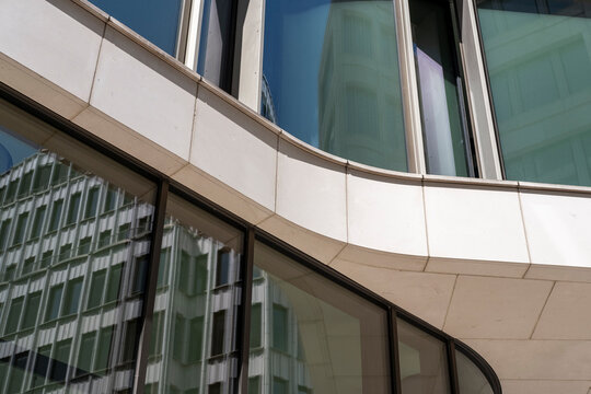 Abstract corporate architecture facade in modern glass showing curvature reflections and clean lines composed for a sleek perspective view