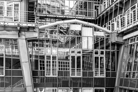 Abstract pattern of industrial architecture as construction scaffolding frames facade windows and structure revealing layered complexity