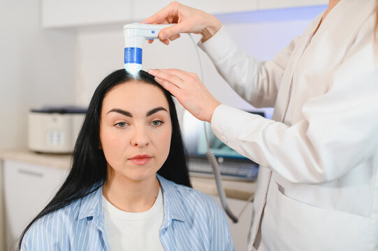 Doctor diagnoses the structure of the hair. Consultation with a trichologist