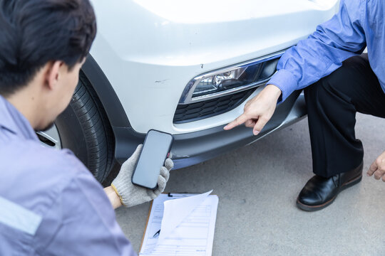 Auto repair shop, small business owner, garage, technology mechanic photographing wheel damage for inspection, customer consultation, quotation online service estimate, insurance claim agent support.