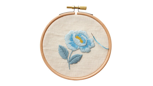 Isolated handcrafted blue flower embroidery art in a wooden hoop with needle and thread