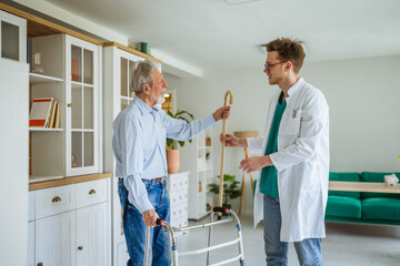 Caregiver assisting senior man with walking stick and walker