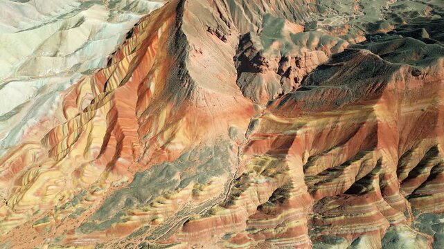 Aerial drone view of layered sandstone cliff formations in Zhangye Danxia Geopark, Gansu Province, China