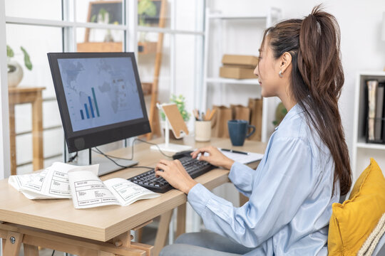 Ecommerce, order, management, online seller points at business chart on monitor, studying shipment results and sales data from home office desk, quality control planning, woman working at home