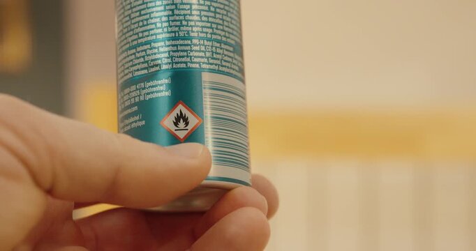 Close-up of a flammable hazard pictogram on an aerosol spray can.
