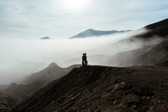 Romantic couple embracing on a foggy mountain landscape in Java Indonesia