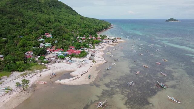 Aerial drone view of Scallop Beach on Guimaras Island Philippines showing tropical water and scallop shell shoreline. Scenic island coast surrounded by lush vegetation and peaceful seaside.