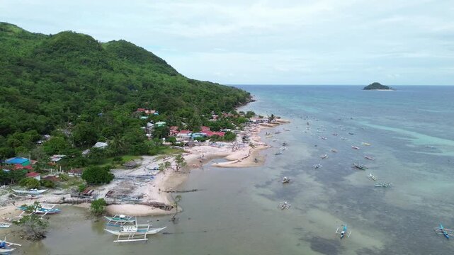 Aerial drone view of Scallop Beach on Guimaras Island Philippines showing tropical water and scallop shell shoreline. Scenic island coast surrounded by lush vegetation and peaceful seaside.