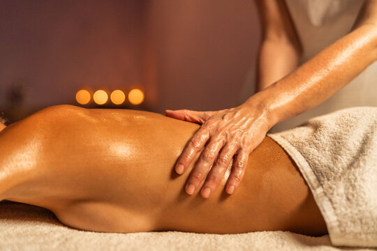 Young woman receiving massage in spa salon - Beautiful girl wearing towels lying on massage tables at spa resort