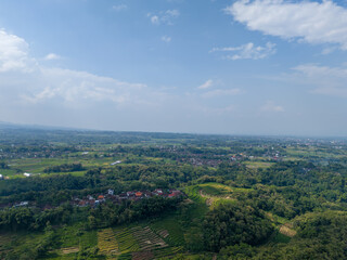 Fototapeta premium Scenic aerial landscape of traditional terraced paddy fields on the fertile slopes of Mount Lawu.