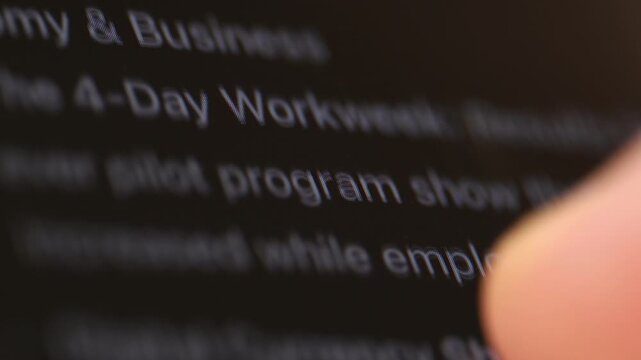 Finger scrolling text on computer screen macro with shallow depth of field. Dark theme 