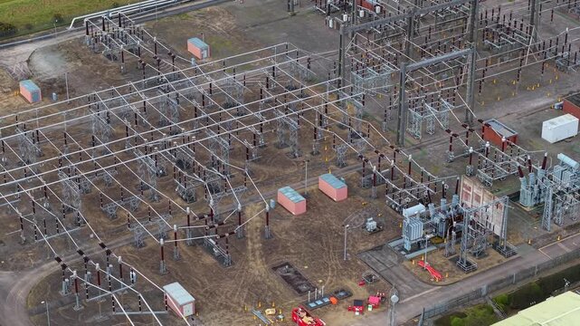 Aerial view of the Hams Hall Substation, where a metallic web of power lines and transformers stand against the earthy tones of the landscape, Birmingham, United Kingdom.