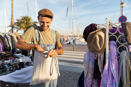 Man browsing sustainable fashion at flea market outdoors urban lifestyle