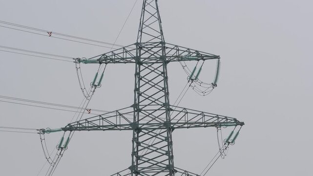 Downward camera tilt showing transmission tower arms and insulators