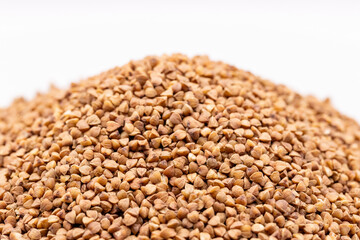Obraz premium Macro buckwheat texture. Brown buckwheat seeds isolated on white background, close up. Buckwheat background.