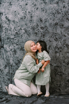 Joyful Muslim Mother and Daughter Sharing a Sweet Kiss