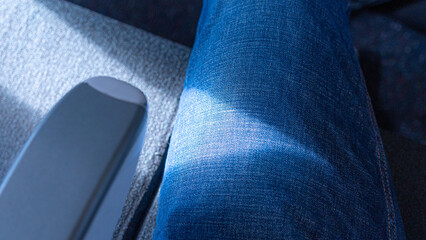 Passenger Perspective Showing Blue Denim Jeans and Seating Area with Natural Lighting for Transportation Themes © Andik
