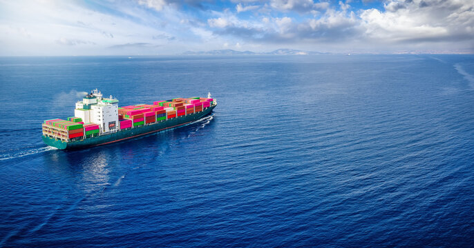 Rear view of a loaded container ship sailing over the ocean for industry, shipping and cargo with copy space