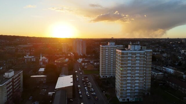 An aerial view of a London council housing estate with high rise apartment blocks at sunset.