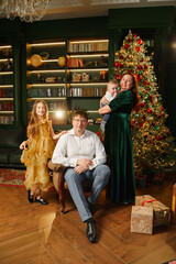 Family celebration with Christmas tree and gifts in cozy living room