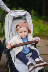 Cute toddler in stroller enjoying a sunny day outdoors