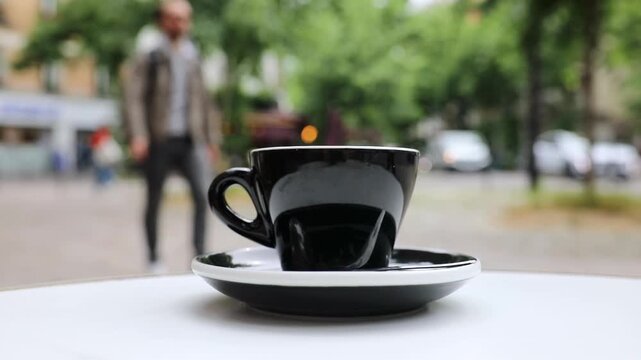 Cup of fresh hot coffee on the table of an outdoor cafe in Paris, France.