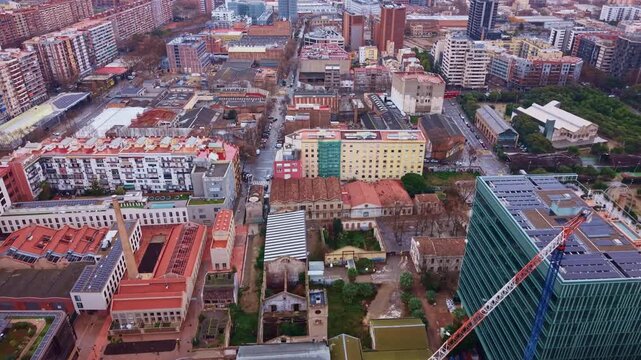 Drone view of city blocks, rooftops and streets along Avinguda Diagonal in the Poblenou district of Barcelona, Spain