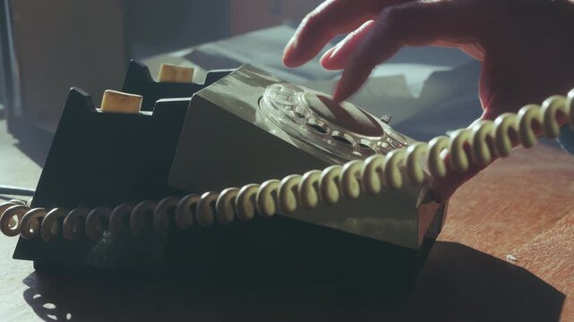 Close-up of a hand dialing a vintage telephone, then replacing the handset after an engaged signal. Ideal for frustration or busy office themes.