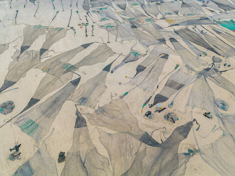 Aerial view of fishing nets spread out on sandy ground, creating a textured pattern of light and shadow, Cox's Bazar, Chittagong Division, Bangladesh.